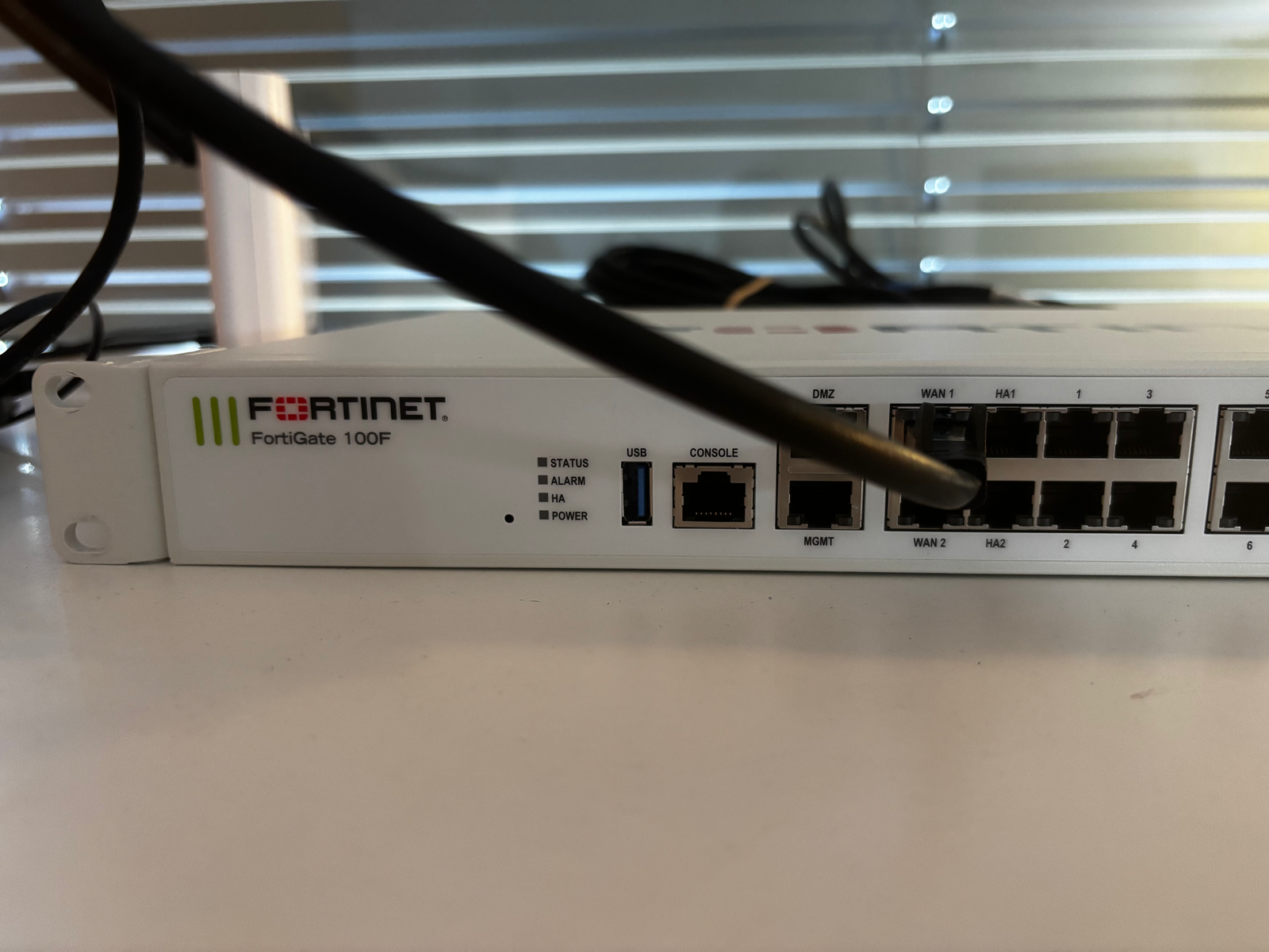 FortiGate 100F on the desk, fresh from the box